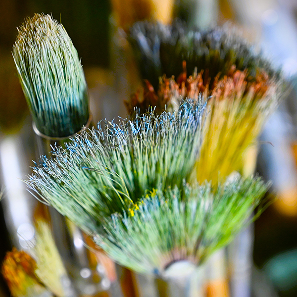 Used paintbrushes with a close up of the bristles.