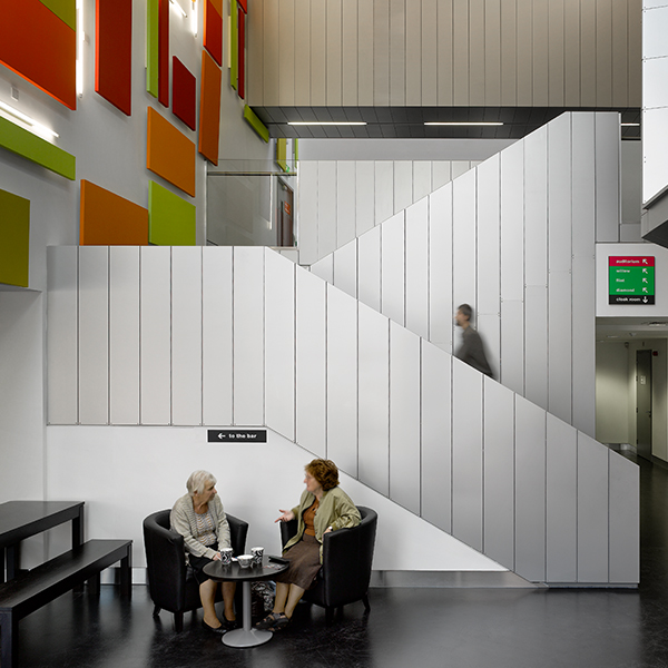 Two women sat at a table enjoying hot drinks.