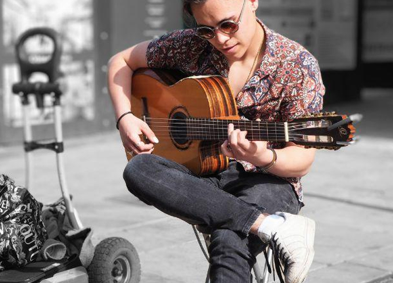 A musician playing the guitar outside the Cornerstone cafe.